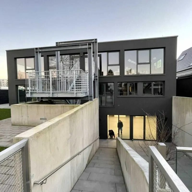 Moderne Fenster in einem zweistöckigen Gebäude von NORTA. Ideal für effiziente Energieeinsparung und modernes Design.