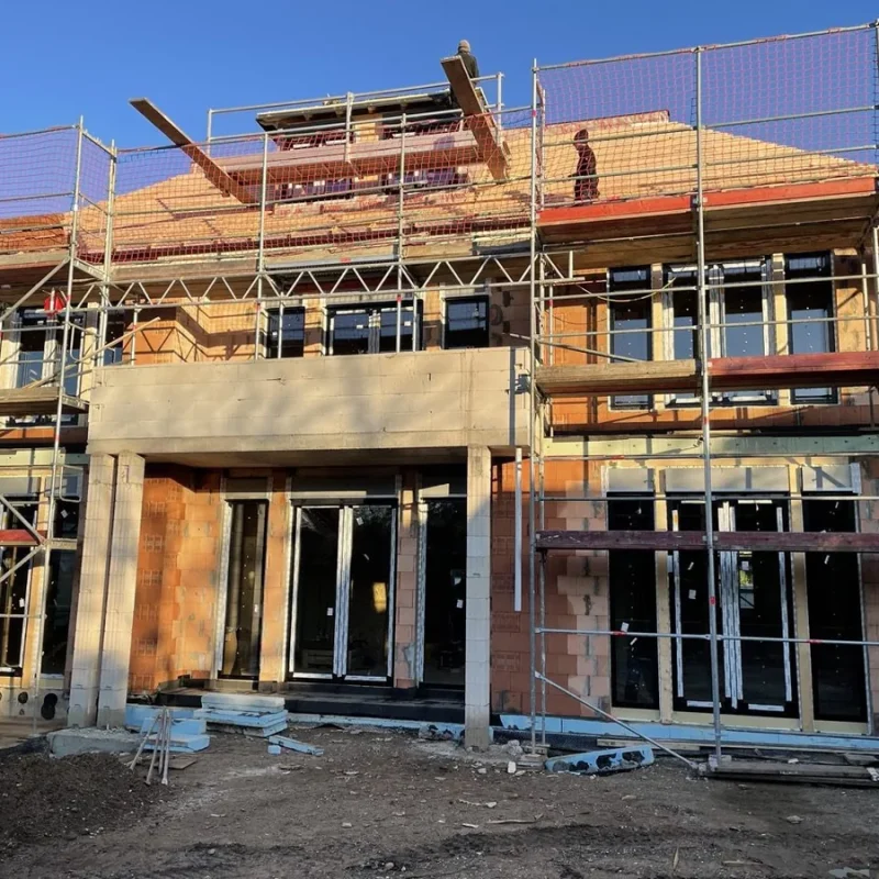 Fenstermontage in Rohbau mit Baugerüst. Hochwertige NORTA-Konstruktion für effiziente Installation und modernes Design.