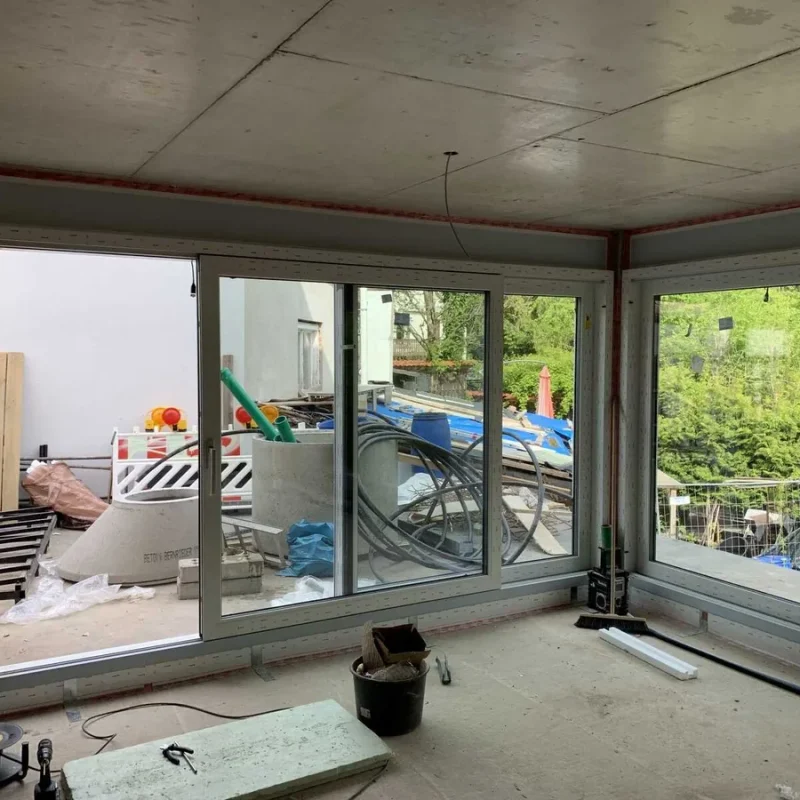 Großes Eckfenster in einem Neubau mit Blick auf eine Baustelle. Hochwertige Fensterlösung von NORTA für optimale Lichtverhältnisse.