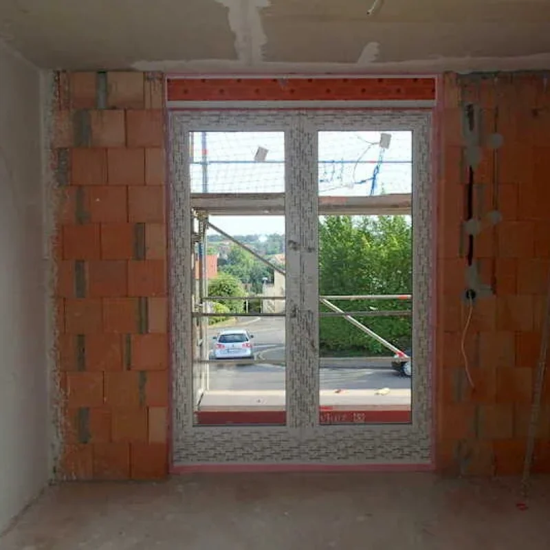 Fensterinstallation im Rohbau mit Blick nach draußen von NORTA. Hochwertige Lösung für optimalen Wohnkomfort und Lichtdurchlass.