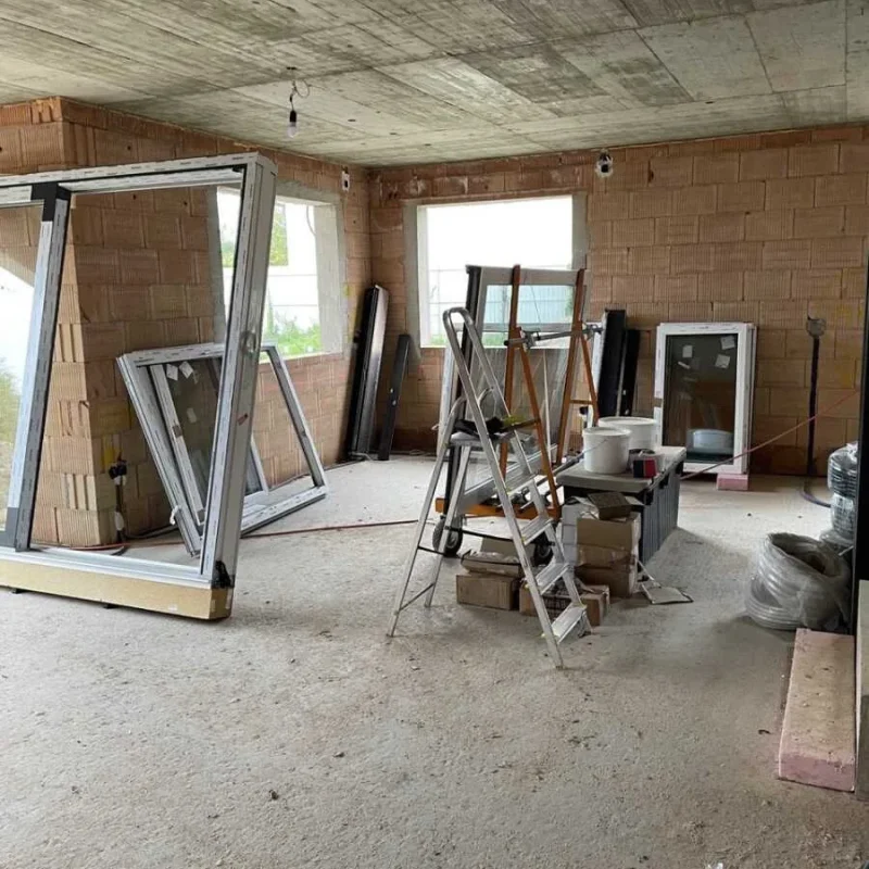 Montage von Fenstern im Rohbau eines Einfamilienhauses von NORTA. Geöffnete Profile und Zubehör im Innenraum.