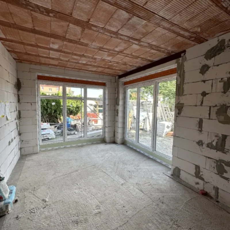 Geräumiger Neubau mit großen Fenstern von NORTA. Bietet viel Tageslicht und eine moderne Wohnatmosphäre.