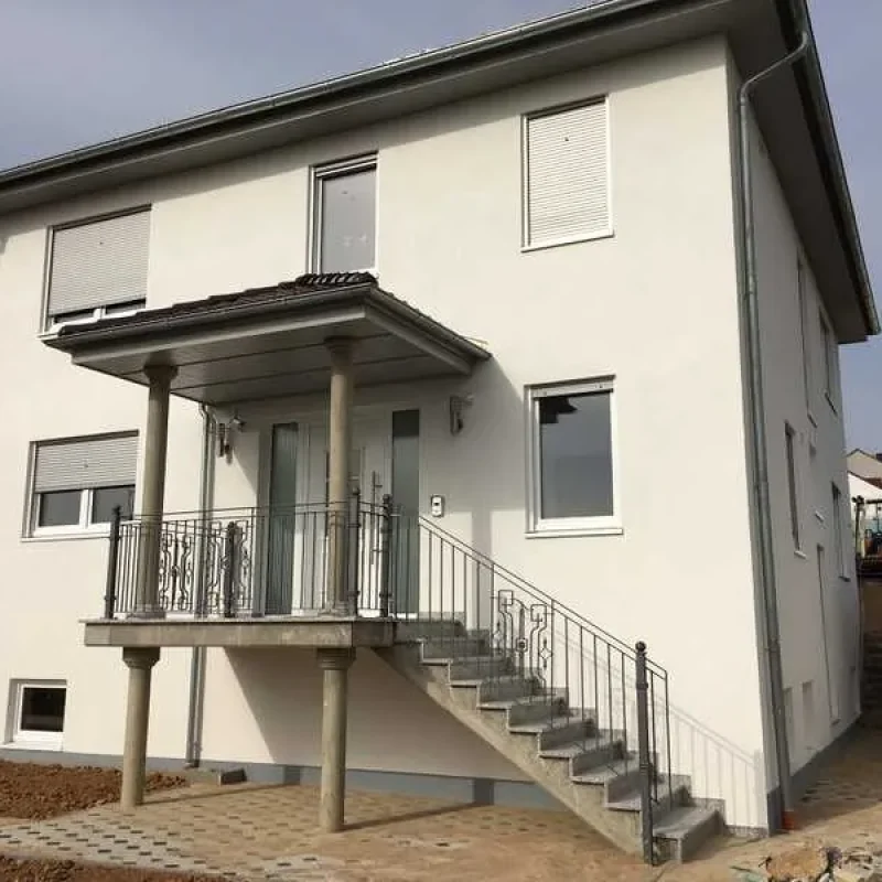 Modernes Haus mit weißen Fenstern und Rollläden von NORTA. Stilvolle, energieeffiziente Lösung für optimalen Komfort und Sicherheit.