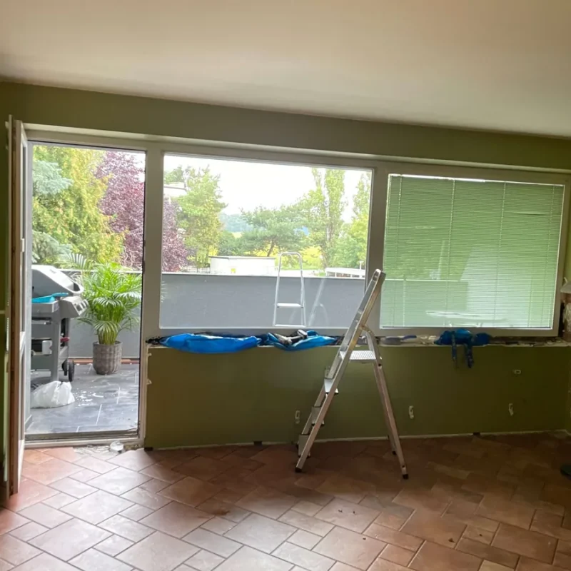 Sanierung eines Fensters in einem modernen Wohnraum von NORTA. Verbesserte Energieeffizienz und stilvolle Optik mit Blick auf Terrasse.