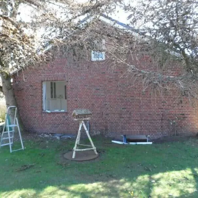 Backsteinhaus mit Fensterbaustelle auf Föhr. Vorbereitung für Fensterinstallation durch NORTA für moderne Wohnqualität.