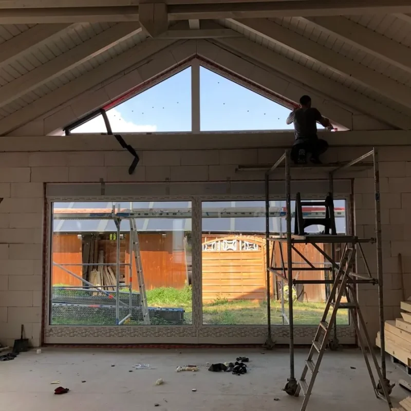 Montage einer großen Fensterfront in einem modernen Wohnraum von NORTA. Optimale Lichtdurchflutung und Energieeffizienz.