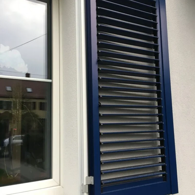 Fensterladen aus Aluminium in Blau von NORTA. Robuste und stilvolle Lösung für zuverlässigen Sonnenschutz und ansprechendes Design.