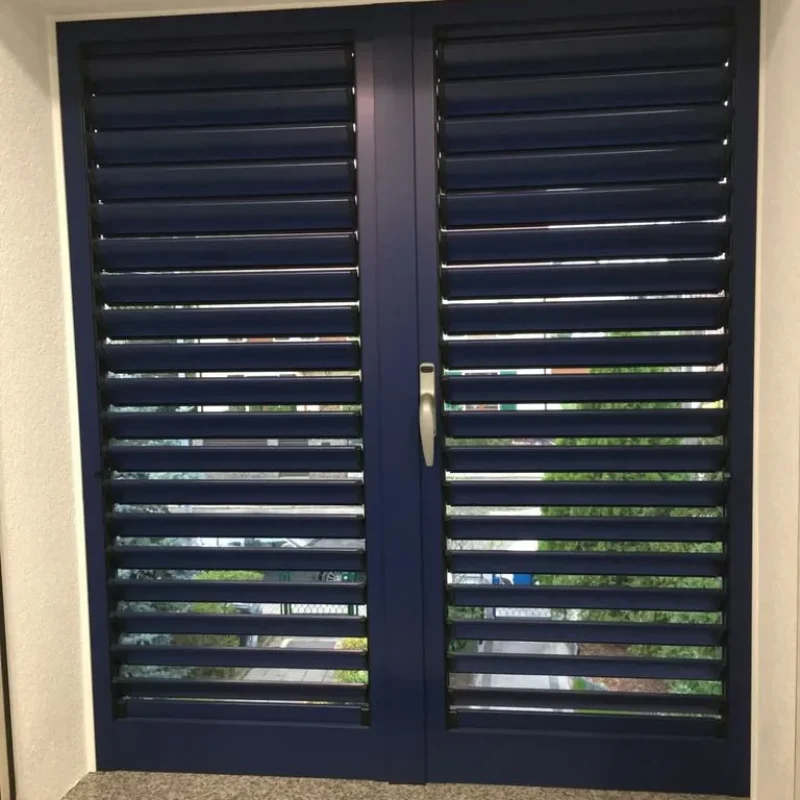Blauer Fensterladen aus Aluminium von NORTA. Robust und langlebig, ideal zur Verschattung und Dekoration von Fenstern.