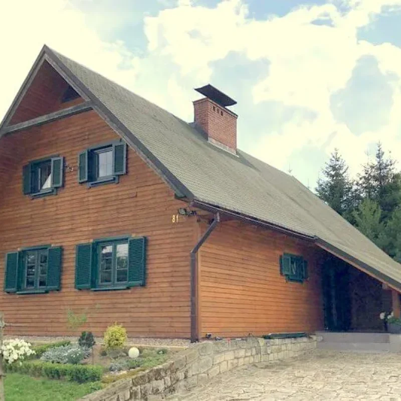 Traditionelles Holzhaus mit Fensterläden aus Aluminiumprofilen von NORTA. Kombiniert Robustheit mit klassischem Design.