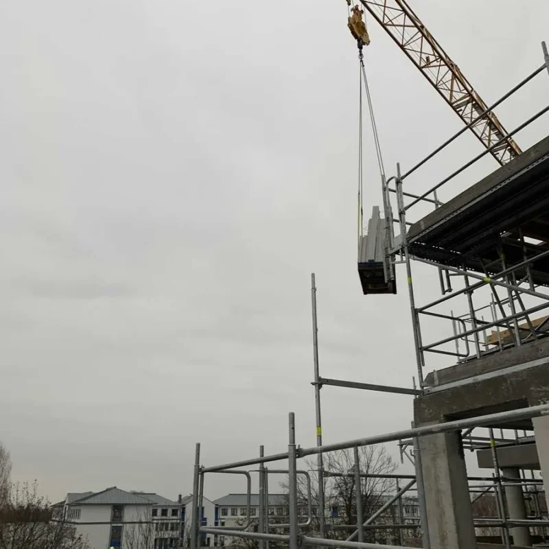 Fenster wird mittels Kran zu einem Neubau gehoben. Effiziente Montage von NORTA für moderne Bauprojekte.