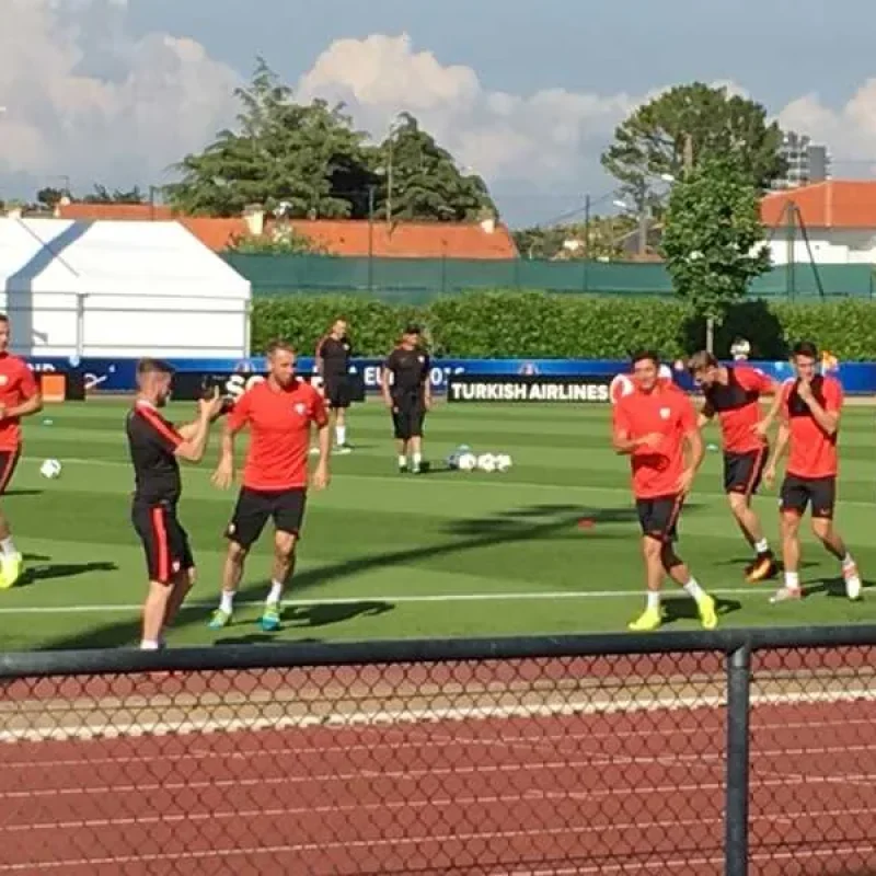 Fußballspieler im roten Trikot trainieren auf einem grünen Rasenplatz bei NORTA. Optimale Bedingungen für Leistungssport.