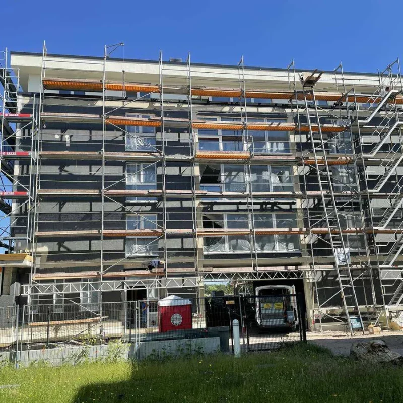 Mehrstöckiges Gebäude während der Sanierung mit Gerüst. Modernisierung für Energieeffizienz von NORTA.