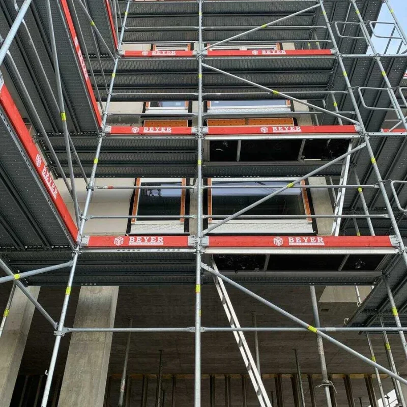 Gerüst an einem mehrstöckigen Gebäude, ermöglicht sicheren Zugang für Arbeiten an der Fassade. Stabilität und Sicherheit von NORTA.