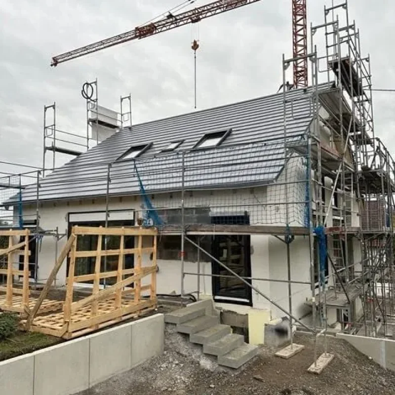 Haus während der Sanierung mit Baugerüst und Dachkonstruktion von NORTA. Robuste Lösungen für effiziente Bauprojekte.