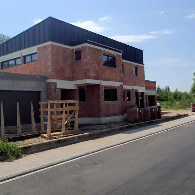 Haus im Rohbau mit neu installierten Fenstern von NORTA. Moderne Bauweise für effiziente Energieeinsparung.