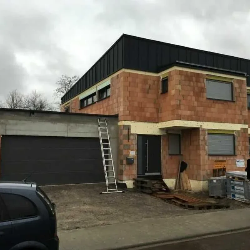 Haus im Rohbau mit integrierten Rollläden von NORTA an Fenstern, moderne Architektur und praktische Baulösung.