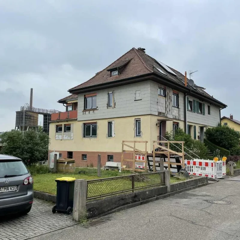 Zweistöckiges Haus in Gernsbach in Sanierung. Außenfassade wird erneuert, Baugerüste und Absperrungen sind sichtbar.