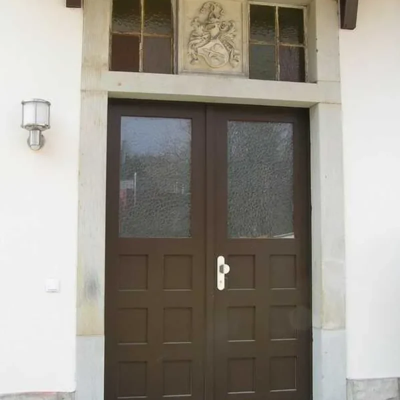 Holzhaustür mit Glasfenstern und Steinverzierung in Dresden. Klassisches Design von NORTA, robust und sicher.