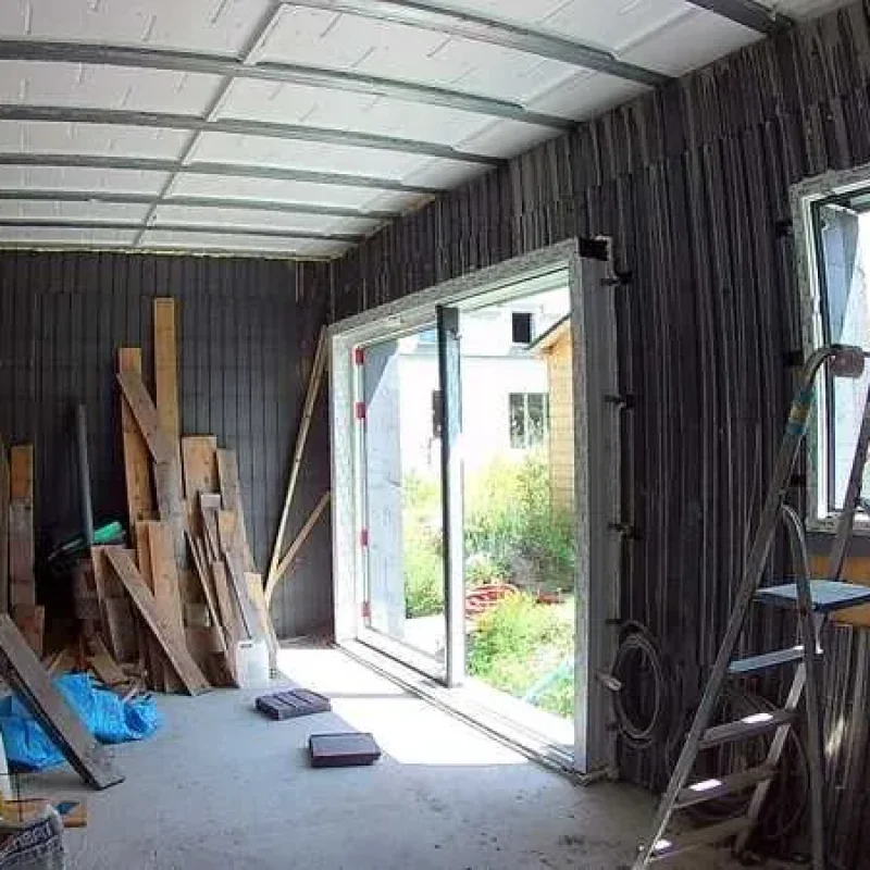 Montage einer Hebe-Schiebe-Tür von NORTA. Baustellenansicht mit vorbereiteten Rahmen für hochwertige Türeninstallation.