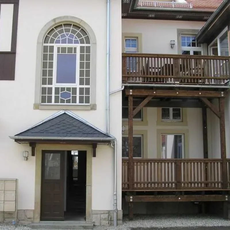 Eingang eines historischen Gebäudes mit verzierten Fenstern und Holzveranda von NORTA.