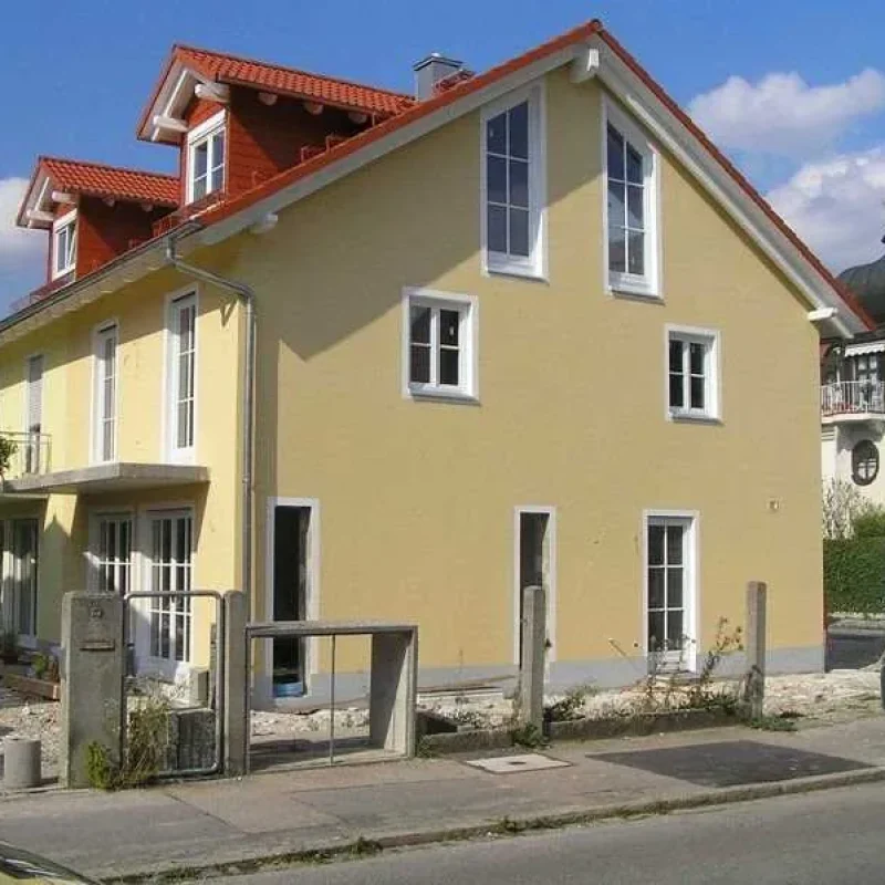 Gelbes Haus mit modernen Holzfenstern in München. NORTA bietet ästhetische und energieeffiziente Lösungen für Ihr Zuhause.