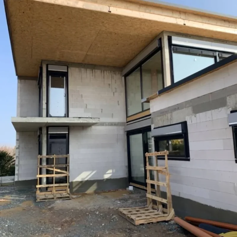 Modernes Einfamilienhaus im Bau mit großen Fenstern in Chemnitz, präsentiert von NORTA. Innovative Bauweise für stilvolle Wohnräume.