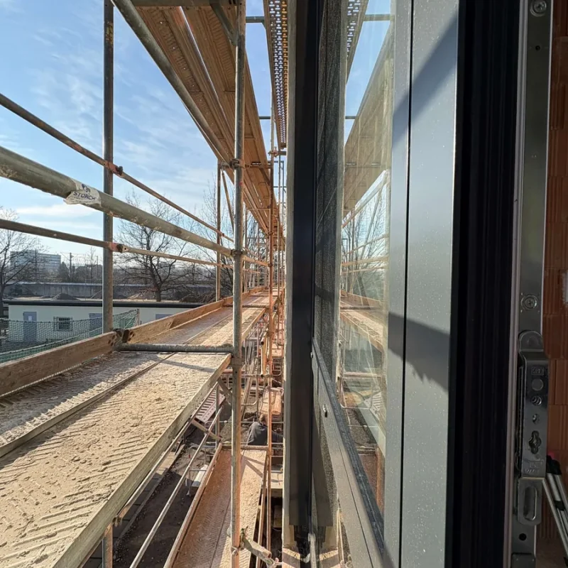 Montage eines Fensters an einem Gerüst von NORTA. Optimale Lösung für energieeffiziente Bauarbeiten und präzise Installation.