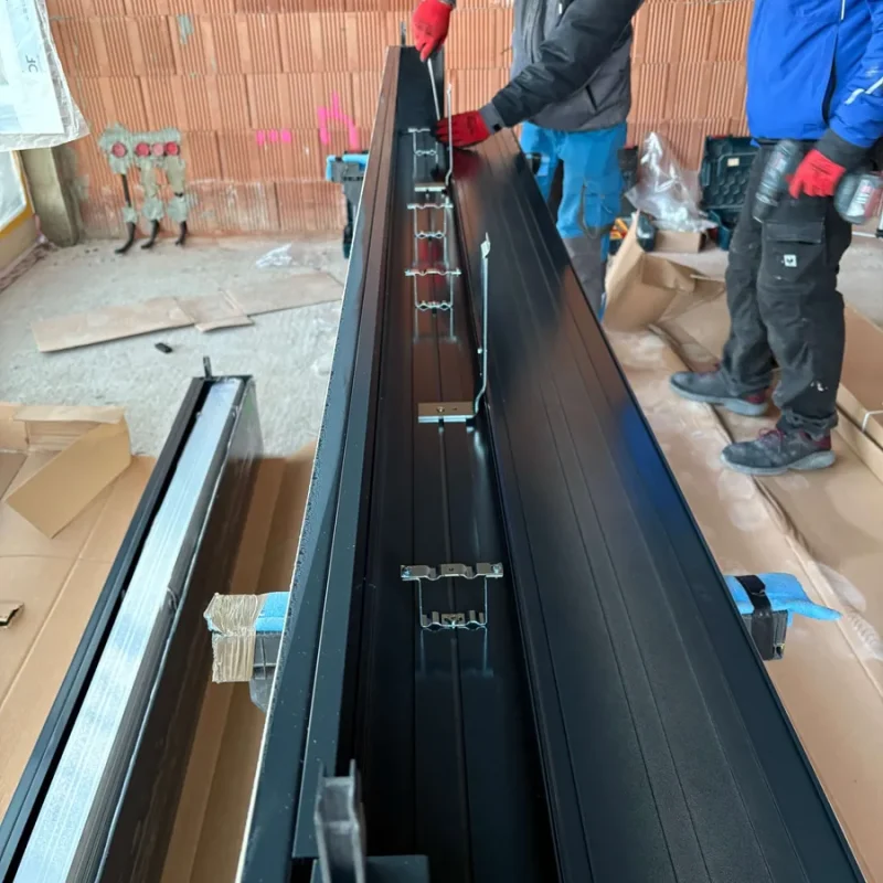 Montage von Rollladenführungen bei NORTA. Handwerker bei der Installation für optimalen Sonnenschutz und Energieeffizienz.