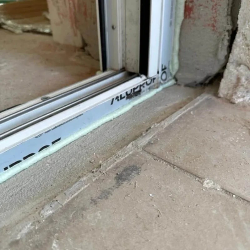 Montagedetail einer Türschwelle von NORTA. Präzise Abdichtung und Installation für optimale Dämmung und Langlebigkeit.
