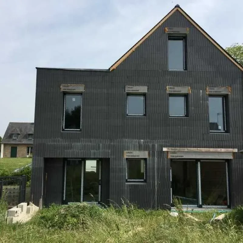 Moderne Fenster in Anthrazit an einer Fassade montiert. NORTA bietet hochwertige Lösungen für energieeffiziente Bauten.