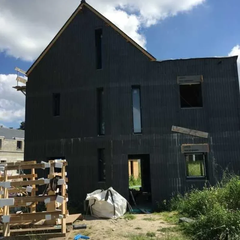 Baustelle eines modernen Hauses in Frankreich mit dunkler Fassade und NORTA Fenstern. Fertigstellung für optimales Wohnklima.