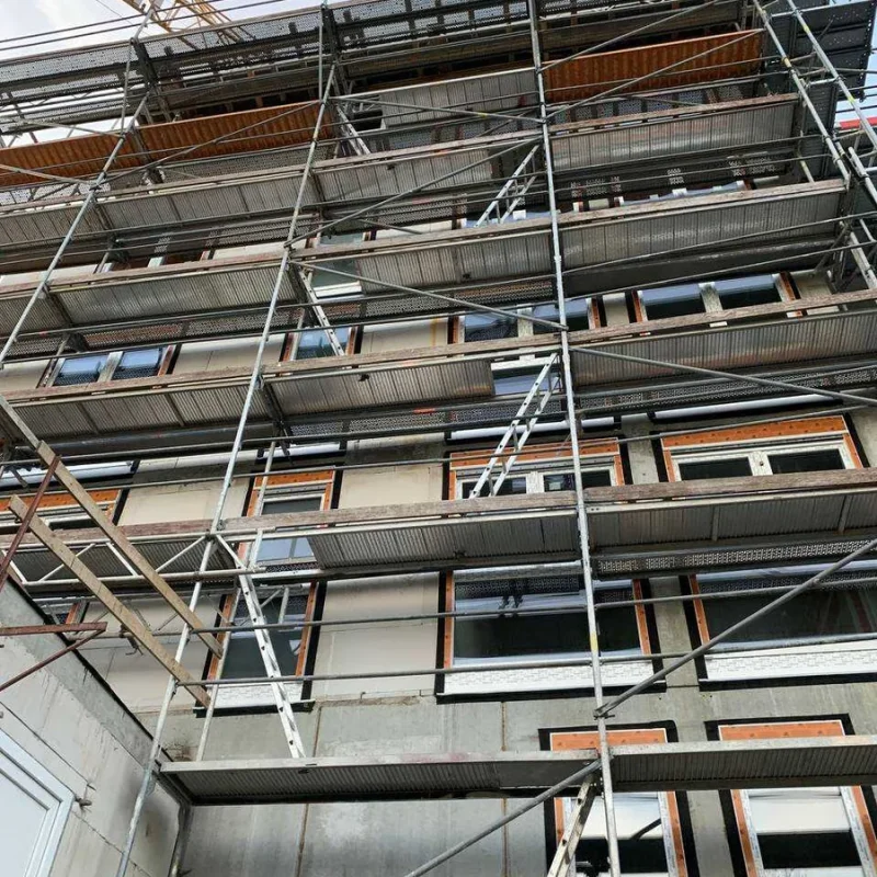 Gerüst an einer Gebäudeaußenwand bei einem Bauprojekt von NORTA. Optimale Vorbereitung für Fenster- und Türmontage.