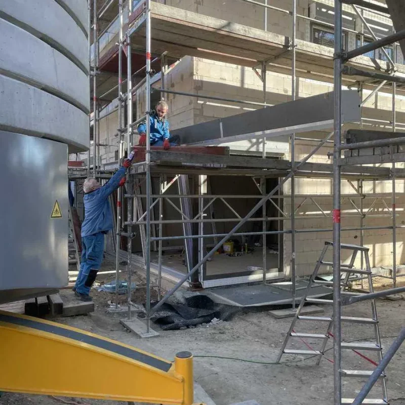 Bauarbeiter auf einem Gerüst bei der Montage eines Doppelhauses. Sicherer Aufbau für effektive Baufortschritte mit NORTA.