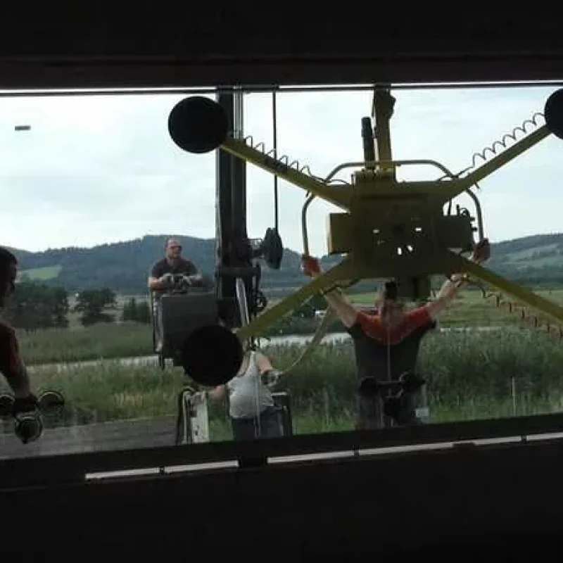 Großes Fenster wird in Zloty Stok, Polen von NORTA montiert. Fachkräfte installieren unter freiem Himmel mit Spezialgeräten.