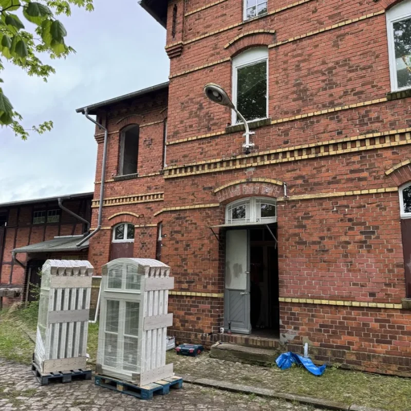 Montage von Holzfenstern an einem Backsteingebäude. Hochwertige Fensterlösungen von NORTA für denkmalgeschützte Gebäude.