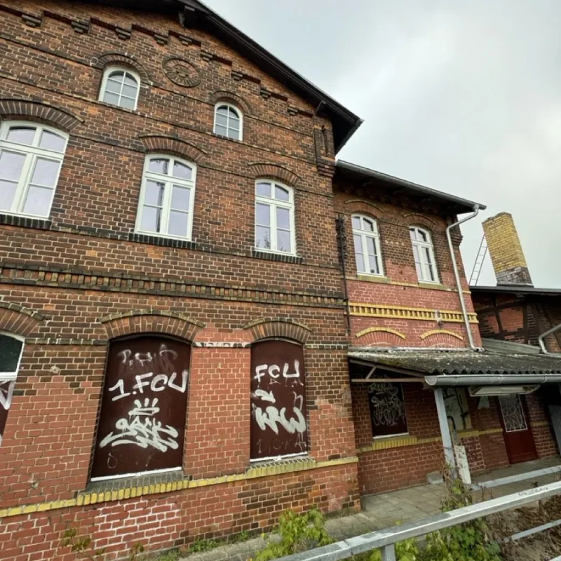 Backsteingebäude mit weißen Holzfenstern von NORTA. Kombination aus traditionellem Charme und moderner Technik.