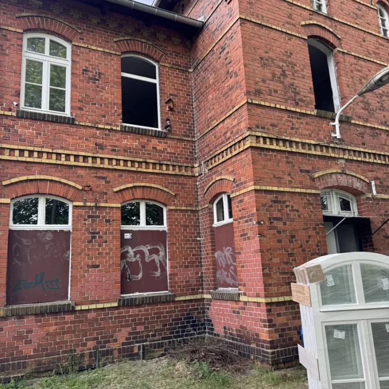 Montage von Holzfenstern in einem alten Backsteingebäude. NORTA bietet hochwertige Lösungen für historische Bauten.