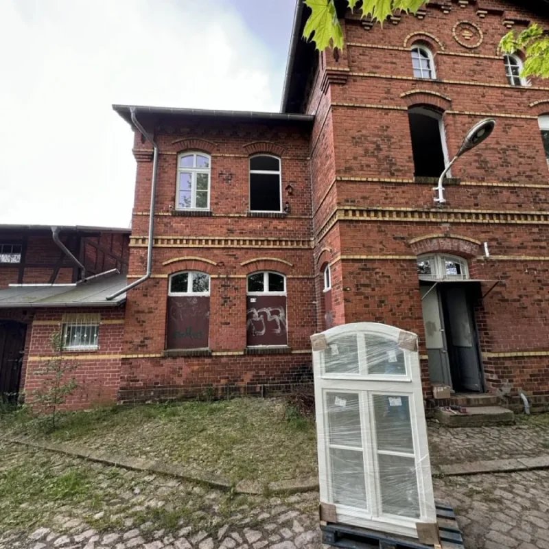 Holzfenster vor historischem Backsteingebäude in Havelsee. Hochwertige Fensterlösung von NORTA für stilvolle Renovierungen.