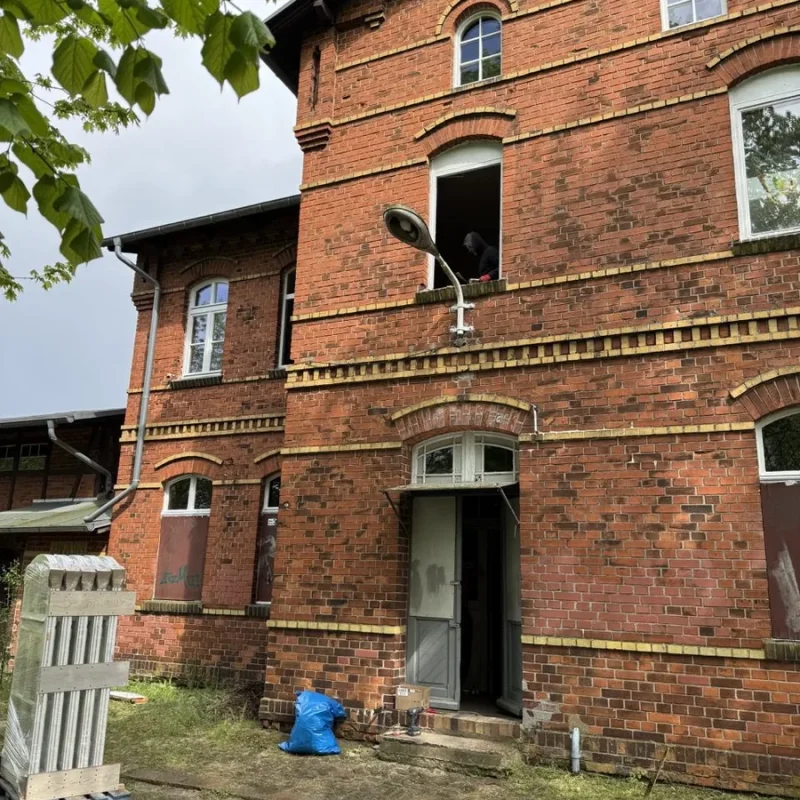 Montage von Holzfenstern in einem Backsteingebäude. NORTA bietet hochwertige Lösungen für Energieeffizienz und Stabilität.