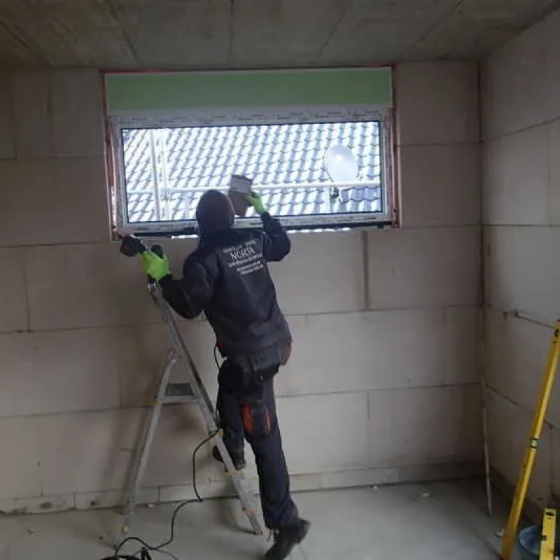 Montage eines Schüco Fensters bei einem Neubau von NORTA. Handwerker bei der Arbeit für optimale Installation.