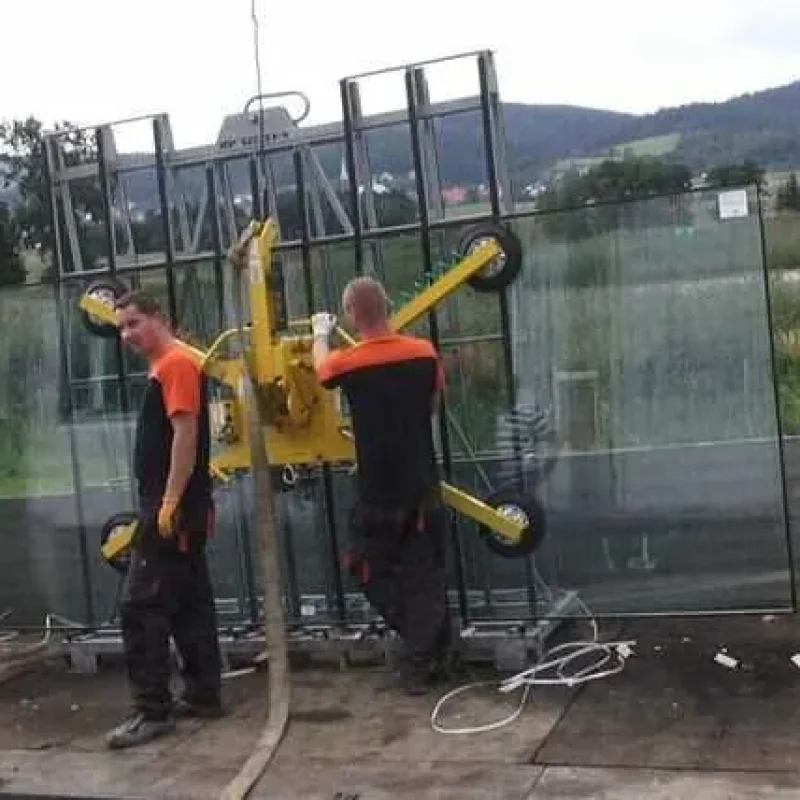 Glasmontage von NORTA in Polen. Arbeiter installieren große Glasplatten mit einem Hebegerät auf einem LKW.