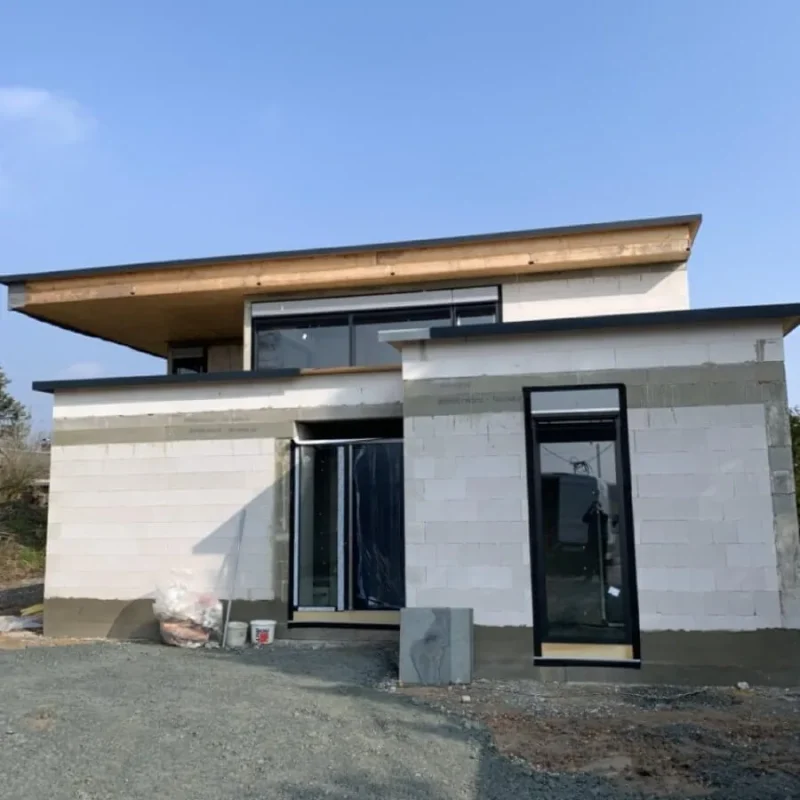 Modernes Einfamilienhaus im Rohbauzustand von NORTA. Stilvolle Architektur mit Flachdach und großen Fensterelementen.