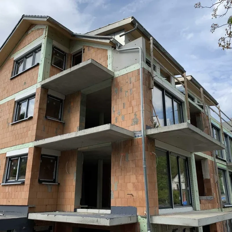 Modernes Neubauprojekt mit großen Fenstern in Muenchen. NORTA bietet langlebige Lösungen für effektive Belichtung und Design.