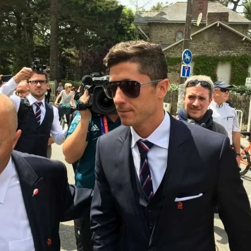 Person in Anzug mit Sonnenbrille in einer Menschenmenge in La Baule, Frankreich.