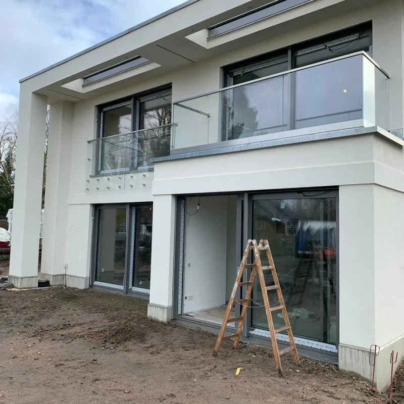 Modernes Haus mit großen Alufenstern und Glasgeländer von NORTA. Hochwertige Kombination für lichtdurchflutete Räume.