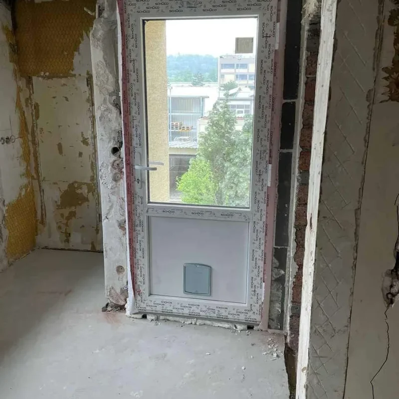 PVC-Tür mit Katzentür, im Rahmen einer Gebäudesanierung installiert. Modernes Design von NORTA für hohe Energieeffizienz.