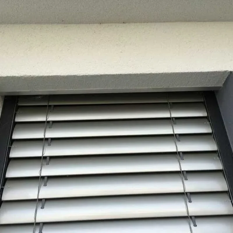 Raffstore im silbernen Aufsatzkasten an Schüco-Fenster von NORTA. Optimale Lichtregulierung und Sichtschutz für moderne Häuser.