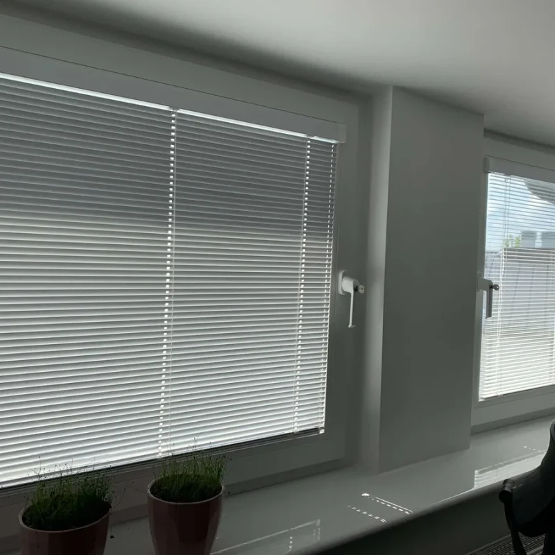 Moderner Innen-Raffstore in Grau von NORTA. Eleganter Sicht- und Sonnenschutz für Wohnräume mit optimaler Lichtregulierung.