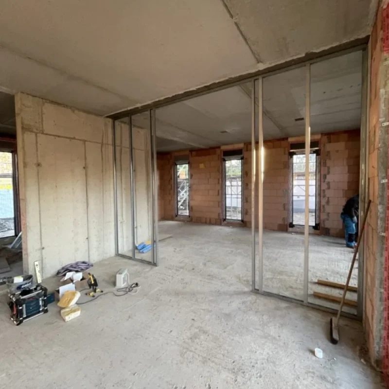 Innenansicht eines Rohbaus mit Fensterfront in der Bauphase. Optimale Vorbereitung für den Fenstereinbau bei NORTA.