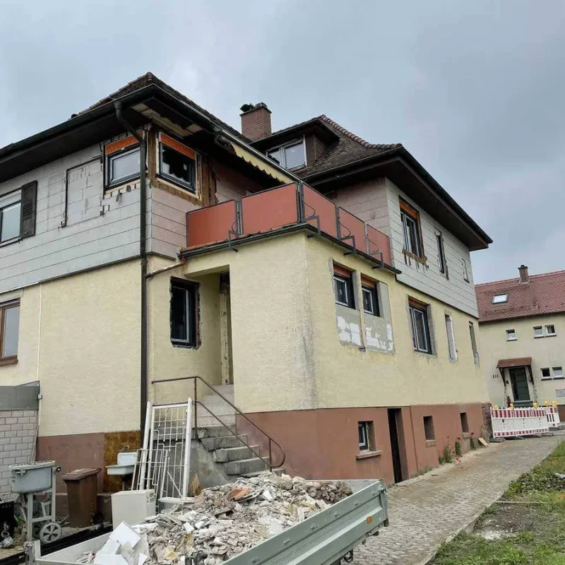 Gebäude während der Sanierung in Gernsbach mit Bauabfällen auf Anhänger. NORTA bietet hochwertige Sanierungslösungen.